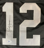 The Rich Gannon Oakland Signed Black Football Jersey by Sports Integrity features a large silver number 12, a black marker signature on the left of the number, and a small BAS authentication sticker at the bottom of the 1.