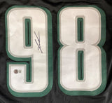 The Sports Integrity Jalen Carter Philadelphia black football jersey features large white numbers 98 outlined in green, a black ink signature on the left digit, and an authenticity sticker below.