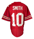 A Troy Smith Ohio State red football jersey by Sports Integrity with white sleeve stripes, "SMITH" and number 10 on the back, plus a Troy Smith autograph left of the number and a PSA hologram.