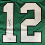 Randall Cunningham Philadelphia Signed Kelly Green Football Jersey by Sports Integrity features a large white number 12 outlined in black, signed in black ink on the left of the 1, and includes a BAS authentication sticker near the bottom.