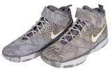A pair of Kobe Bryant Lakers Signed Nike Zoom Kobe II Prelude high-top shoes by Sports Integrity, featuring gray marbled design with gold and white accents, KOBE branding, and signature on the left toe.
