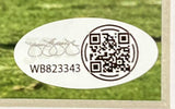 An oval white sticker with a black QR code, printed signature, and code WB823343, from Sports Integrity's Tyler Warren Signed Framed 8x10 Penn State Nittany Lions Photo JSA, is shown on green grass.