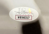 A white oval sticker with code WB540317 in black text, outlined in red, is placed over a faint signature and a yellow triangle on the Brandon Graham Signed 11x14 Eagles Tom Brady Strip Sack Photo by Sports Integrity.