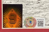 Close-up of three stickers on a Sports Integrity Ted Williams Signed Framed 16x20 Boston Red Sox Running Photo BAS LOA: an orange holographic sticker with '9', a circular hologram, and a white label bearing QR code AC66425.