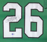 The Sports Integrity Saquon Barkley Philadelphia Signed Framed Kelly Green Football Jersey (BAS ITP) features a large white number 26 outlined in black, with a black ink signature on the left of the "2" and an authenticity sticker below.
