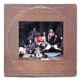 The Aerosmith Toys in the Attic 1975 Vinyl Record 1 by Sports Integrity features a vintage cover with five band members posing indoors among props like a rocking horse and hats, set against a brown background with gold song titles and credits.