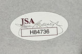Sports Integrity’s Alice Cooper Signed Framed 11x14 Photo includes an oval JSA sticker with code H84736, red lettering, a faint signature in the background, and a bordered box on a textured gray surface.