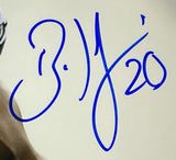 A bold blue handwritten signature with the number 20 appears on a light background in this Sports Integrity Brian Dawkins Signed Framed 16x20 Philadelphia Eagles Smoke Photo BAS. The stylized script features flowing initials or symbols.