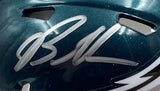 A close-up of a Sports Integrity Brandon Graham Signed Eagles Mini Speed Helmet with a silver autograph, partially visible vent holes, and part of a white wing design near the bottom edge. Includes BAS and Super Bowl 59 LIX case.