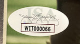 Oval JSA authentication sticker with signature and code WIT000066 is on the Sports Integrity Calvin Johnson Signed Framed 8x10 Detroit Lions Photo, shown against a blurred green background.