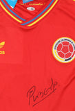 The Sports Integrity Carlos Valderrama Signed Colombia Adidas Soccer Jersey features a red design, yellow Adidas logo, team badge, blue/yellow collar trim, and Valderrama's signature near the bottom with JSA QR hologram.