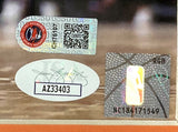 Close-up of three authentication stickers on the Chet Holmgren Signed Framed 16x20 Oklahoma City Thunder Photo by Sports Integrity: a QR code with logo, an oval JSA sticker signed AZ33403, and a basketball hologram marked RGB NC184171549.