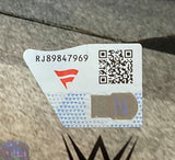 A security sticker with code RJ89847969, a red stylized F logo, QR code, and silver holographic section is attached to the Sports Integrity CM Punk Signed Framed 8x10 WWE Return Photo Fanatics. A partial black W logo appears underneath.