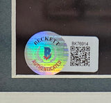A holographic Beckett Authenticated sticker and a white label with the code BK76914 and QR code are on the corner of this Sports Integrity John Daly Signed Framed 8x10 PGA Golf Smoking Photo BAS.