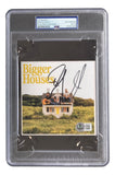 The Dan & Shay Signed Slabbed Bigger Houses CD Insert by Sports Integrity is authenticated by PSA, featuring two men on a small house in a green field and encased in a plastic slab with certification label and sticker.