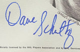 A Dave Schultz signed 8x10 Philadelphia Flyers photo from Sports Integrity (JSA AL44177); blue autograph on a white background, faint printed text and CHARLES SUNS visible to the right.