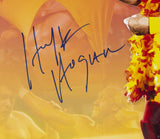 A close-up of a wrestler in a yellow and red feathered boa with Hulk Hogan’s bold blue autograph appears on the Sports Integrity Hulk Hogan Signed Framed 16x20 WWE Photo JSA, set against wrestling action.