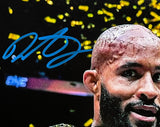 A Demetrious "Mighty Mouse" Johnson Signed 8x10 UFC Photo by Sports Integrity shows Johnson smiling before a backdrop of yellow confetti, with a large blue autograph signed across the upper left. JSA authenticated.