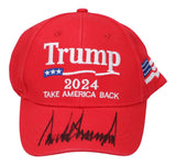 The Sports Integrity President Donald Trump Signed 2024 Take America Back Adjustable Hat features the slogan on the front, an American flag on the side, and a bold black signature across the brim. JSA LOA included.