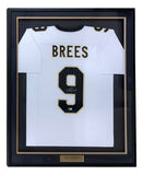 The Sports Integrity Drew Brees New Orleans Signed Framed White Football Jersey BAS features “BREES” and number 9 in black and gold, an autograph on the number, and a gold “DREW BREES.” nameplate at the bottom.