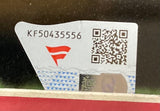 A close-up of a sticker featuring code “KF50435556,” a red logo, QR code, and blue wave designs on shiny backing. The sticker is affixed to the Dylan Crews Signed Framed 16x20 Washington Nationals Photo by Sports Integrity.