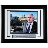 Sports Integrity Mikhail Gorbachev Signed Framed 8x10 Photo (JSA) shows Gorbachev in a suit outdoors with a cityscape and monument behind him; includes nameplate.