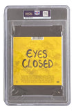 The Ed Sheeran Signed Slabbed Eyes Closed CD Booklet by Sports Integrity comes in a PSA-graded case, featuring yellow artwork with black handwritten "EYES CLOSED" text and small print at the bottom.