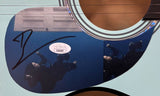 Close-up of a Billie Eilish Signed 39" Hit Me Hard and Soft Blue Acoustic Guitar by Sports Integrity, featuring a reflective, signed sticker of a person underwater in dark clothing; guitar strings and sound hole are also visible.