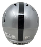 The Howie Long Signed Oakland Raiders FS Replica Speed Helmet by Sports Integrity features a silver finish, black center stripe, bold "RAIDERS" at the base, and visible warning label and authentication sticker.