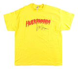 The Sports Integrity Hulk Hogan Signed WWE Hulkamania Yellow T-Shirt features bold red "HULKAMANIA" lettering and a black signature print from Hulk Hogan.
