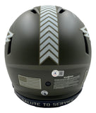 Back view of a Sports Integrity Jalen Hurts Signed Eagles FS Salute to Service Speed Authentic Helmet BAS+Hurts in matte olive green with white chevrons, American flag decal, warning labels, and "SALUTE TO SERVICE" on the lower edge.