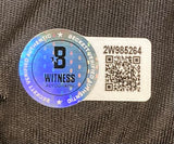 A Beckett B WITNESS AUTOGRAPH sticker with a QR code and serial #2W985264 is shown on Israel Adesanya Signed Custom Black MMA Fight Trunks by Sports Integrity.