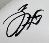 Close-up of a bold, stylized autograph in large, looping letters on a white leather surface of the Jalen Hurts Signed Eagles Logo Football (Sports Integrity), displayed with a Super Bowl 59 case by Fanatics; no visible name in the signature.