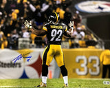A James Harrison Signed 16x20 Pittsburgh Steelers Photo by Sports Integrity shows Harrison (#92) in uniform on the field, arms raised before the crowd, with fans and a large Steelers logo visible in the stadium background.
