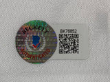 A Beckett sticker with a holographic seal, QR code, and code BK76852 is affixed to a John Daly Right Signed John Daly Logo Golf Flag by Sports Integrity on white textured fabric.
