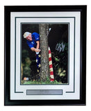 Sports Integrity John Daly Signed Framed 11x14 PGA Golf Tree Swing Photo BAS features a golfer in a blue shirt and American flag pants swinging from behind a tree, with a plaque that reads “John Daly, 2x PGA Major Champion.”.