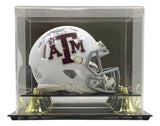 The Sports Integrity Johnny Manziel Signed Texas A&M White Mini Speed Helmet, featuring a maroon ATM logo and facemask, comes displayed in a clear protective case with gold accents and a black base.