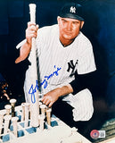 The Sports Integrity Johnny Mize Signed 8x10 New York Yankees Baseball Photo shows Mize in uniform posing with a bat among several bats, featuring his blue autograph and a BAS authentication sticker in the lower right corner.