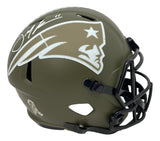 The Julian Edelman Signed Patriots FS Salute To Service Speed Replica Helmet by Sports Integrity features an olive green finish, white team logo, black faceguard, autograph on top, and a military appreciation ribbon decal near the earhole.