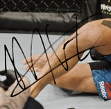 A close-up of Khabib Nurmagomedov’s tattooed legs on the mat in blue Reebok shorts, with a bold black autograph, is featured in this Sports Integrity framed 16x20 UFC Poirier fight photo authenticated by JSA.