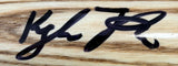 A close-up of a Kyle Tucker Chicago Cubs Signed Rawlings Player Model Baseball Bat by Sports Integrity, featuring bold marker handwriting on the natural wood grain surface.