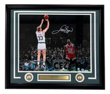 Sports Integrity Larry Bird Signed Framed 16x20 Celtics vs Michael Jordan Photo features Bird in a white jersey shooting as Jordan looks on, signed and includes a gold plaque, authenticated by PSA/DNA.