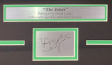 A metal plaque reads: Heath Ledger Framed 13x19 Joker Lithograph Signed by Tony Santiago w/ Laser Auto. By Sports Integrity, with a signed name below, framed in green and black.
