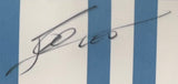 A close-up of Lionel Messi’s signature in black ink on a framed Argentina Adidas soccer jersey with blue and white stripes by Sports Integrity.