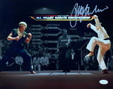 In this Sports Integrity collectible, a Ralph Macchio signed 11x14 "The Karate Kid" Spotlight Photo (JSA ITP), two martial artists battle at the All Valley Karate Championship as one delivers a high kick under the referee's watchful eye.
