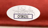 A white oval sticker with code CF38231 in black letters, outlined in purple, appears on the Sports Integrity Ralph Macchio/William Zabka Signed 16x20 Karate Kid Face Off Photo JSA. A faint logo and signature show against a reddish background.