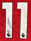 The back of a red Gabriel Martinelli Signed Arsenal Adidas Soccer Jersey 2 BAS by Sports Integrity shows white number 11 with black outline, one digit autographed with authenticity sticker, and Premier League lion logos below each digit.