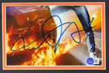 The Sports Integrity Michael J Fox Signed Framed Cut Signature features his large autograph and an 8x10 Back To The Future photo, capturing a close-up of him stepping from a flaming car with fiery tire tracks. BAS authenticated.