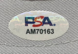 Sports Integrity's Reggie Jackson Signed New York Yankees New Era Baseball Hat 563 Inscribed PSA features an oval holographic PSA sticker with the blue and red logo above code AM70163 on a gray textured surface.
