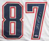 The Rob Gronkowski New England Signed White Football Jersey by Sports Integrity features large blue and red number 87, with Gronkowski’s silver autograph on the 7 and a PSA/DNA authentication hologram near the bottom right.
